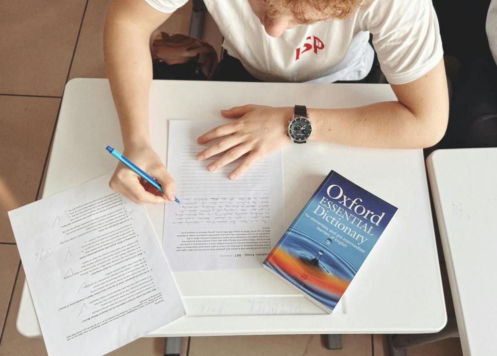 student writing test with oxford dictionary at desk