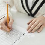 a person writing on paper while cheating