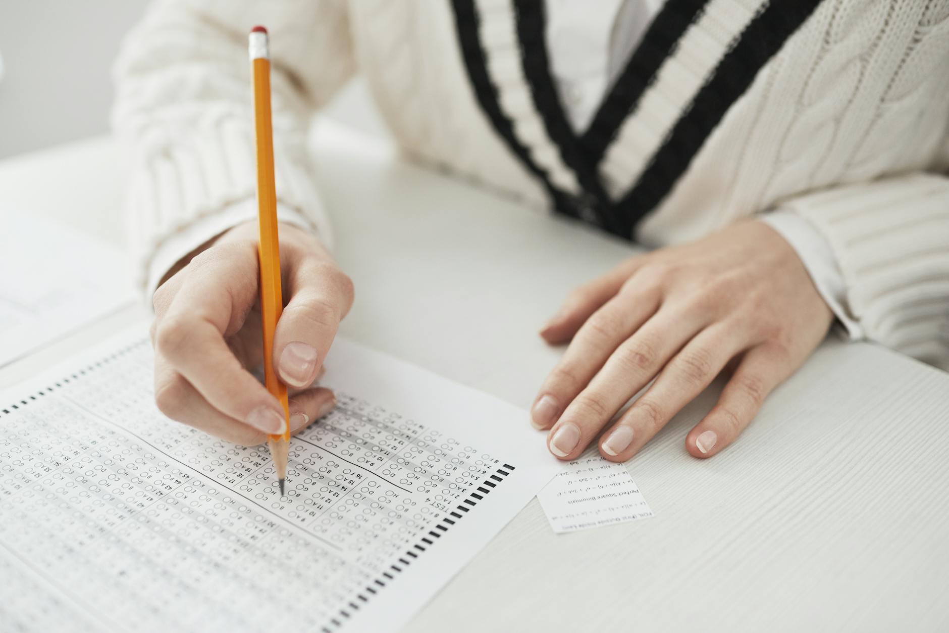 a person writing on paper while cheating